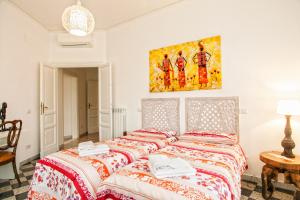 a bedroom with two beds and a painting on the wall at Vatica B&B Roma in Rome