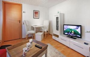 een woonkamer met een televisie en een tafel bij Ferienhaus Zempin Seebad in Zempin