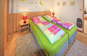 een slaapkamer met een bed met groene en kleurrijke lakens bij Ferienhaus Zempin Seebad in Zempin +4 foto's