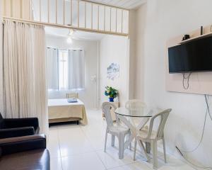 a living room with a glass table and chairs at Studio completo na praia de Copacabana com ar, wifi, netflix, até 4 pessoas, FUNDOS CLARO E SILENCIOSO, pauloangerami PJ135 in Rio de Janeiro