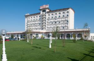 a hotel with a lawn in front of a building at Grand Hotel Italia in Cluj-Napoca