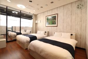 a bedroom with two beds and a mirror at Ideal Momodani イデアール桃谷 in Osaka