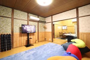 a room with a flat screen tv and a living room at Ideal Momodani イデアール桃谷 in Osaka