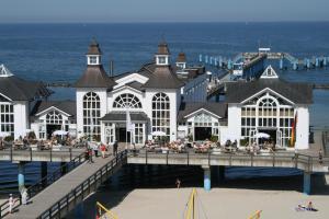 a building on a pier next to the ocean at Ferienwohnung Zum Wald in Ostseebad Sellin