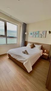 a bedroom with a large bed and a large window at Mian Sapphire Home toà S1 S2 in Ha Long