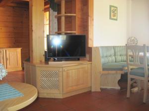 una TV a schermo piatto seduta su un supporto in soggiorno di Ferienhaus Höllwart a Pfarrwerfen