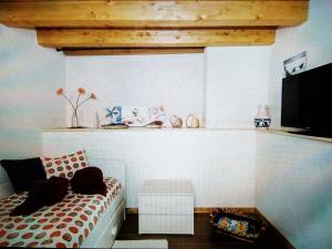 Habitación con cama y estante con TV en Casa Antonella en Siracusa