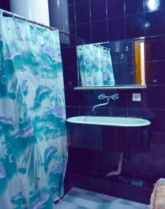 a bathroom with a sink and a shower curtain at Nova Lux Apartments in Tbilisi City