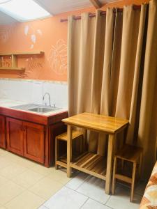 a kitchen with a wooden table and a sink at Caribbean Comfort in Puerto Viejo