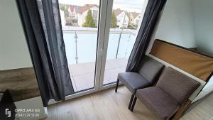 a pair of chairs sitting in front of a window at Deluxe Studio-Apartments in Mörfelden-Walldorf