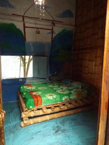 a bed in a room with a painting on the wall at Casa surf arrels in Montañita