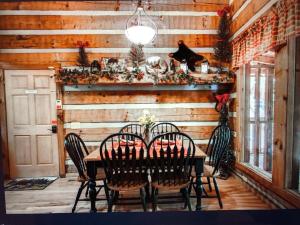 a dining room with a wooden wall with a table and chairs at Mountain Hideaway in Pigeon Forge