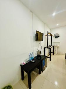a living room with a table and a tv and a room at Luangprabang Residence Boutique Hotel in Luang Prabang