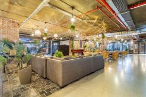 a lobby with a couch and tables and potted plants at Meerendahl Luxury Apartments at Heritage Square in Durbanville
