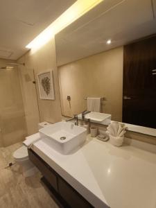 a bathroom with a sink and a toilet and a mirror at luxury central park lagunas in Tulum