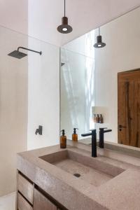 a bathroom with a sink and a mirror at 3BR Home in Gated Community with Private Rooftop Plunge Pool, Grill & Shared Pool in Tulum +22 photos
