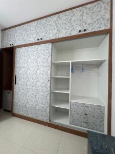 a closet with white shelves in a room at 6Floor in society Ecity ph2 Near TCS Tech Mahindra in Bengaluru