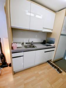a kitchen with white cabinets and a sink at Hongdae Residence-2 1min from Hongik Uni station Exit #1 in Seoul +12 photos