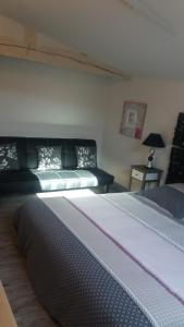 1 dormitorio con 1 cama y 1 sofá en Gîtes Macarien, en Saint-Macaire