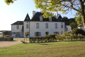 a large white house with a black roof at La Pommeraie in Bruz