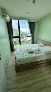a bedroom with a bed and a large window at The Base Hight 一卧公寓 in Phuket Town