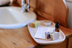 a tray with soap and a bottle on a sink at River Haven in Tauranga