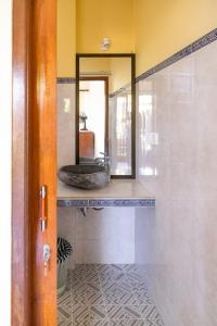 W łazience znajduje się lustro i umywalka. w obiekcie Chandra House Ubud w mieście Ubud