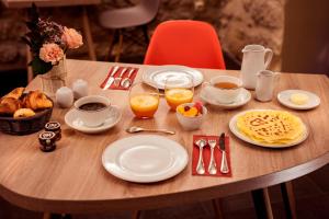a wooden table with plates of breakfast food on it at Hôtel de Lille - Saint-Germain des Près in Paris