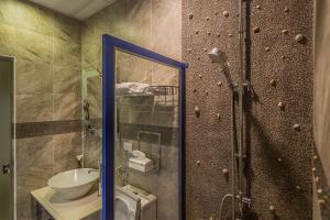 een badkamer met douche, wastafel en spiegel bij Meet ‧ Happiness B&B in Donggang