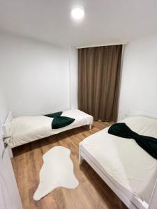 a room with two beds and a window at Besim Apartament in Ferizaj