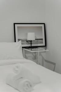 ベルコナンにあるBeautiful 2BR Lakeside Viewのベッドとテーブルの上にランプが置かれた寝室