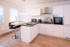 a kitchen with white cabinets and a counter top at Apartments Rudolstadt in Rudolstadt