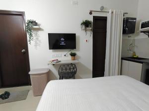 a bedroom with a bed and a desk with a television at 3 Home Tales (Brookefield) in Bengaluru