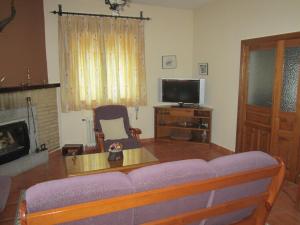 sala de estar con sofá y TV en La Ladera, en Hoyos del Espino