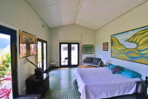 1 dormitorio con 1 cama y una pintura en la pared en Cow Bay Hilltop Escape en Cow Bay