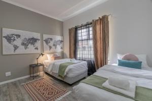 a white room with two beds and a window at Nikita's Holiday Home - Walvis Bay in Walvis Bay