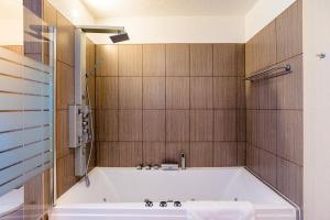 eine Badewanne im Bad mit Holzwänden in der Unterkunft Apartments Rudolstadt in Rudolstadt