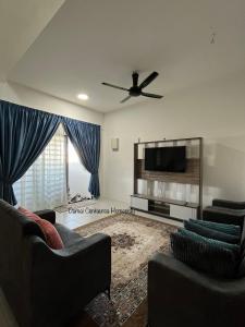 a living room with two couches and a flat screen tv at Damai Centaurea Homestay Utp Uitm Seri Iskandar Perak in Seri Iskandar