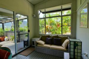 a screened in porch with a couch and windows at Cow Bay Hilltop Escape in Cow Bay