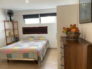 Un dormitorio con una cama y una cómoda de madera. en La casa del viajero junto al mar, en Barrio-Mar