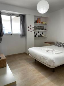 Un dormitorio con una cama blanca y una ventana. en La casa del viajero junto al mar, en Barrio-Mar