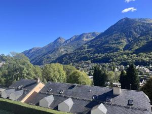 a group of houses with mountains in the background at Appartement neuf 6 pers, balcon, parking à Cauterets - FR-1-812-49 in Cauterets +4 photos