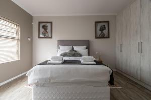 a white bedroom with a large bed in it at Nikita's Holiday Home - Walvis Bay in Walvis Bay