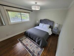 a bedroom with a bed and a window and a rug at Cozy Urban Cottage Close to Lake Ontario in Burlington
