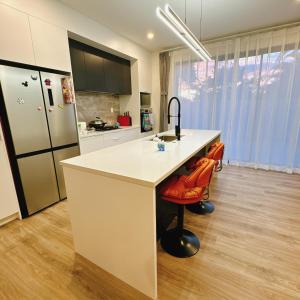 オークランドにあるRoom at Brand new house at Lincoln Roadのキッチン(白いカウンター、冷蔵庫付)