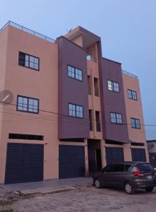 a building with a car parked in front of it at L'appart D' LJ in Cotonou