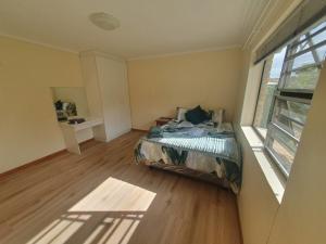 ein kleines Schlafzimmer mit einem Bett und einem Fenster in der Unterkunft 36 Steps to Beach Sand in Gqeberha