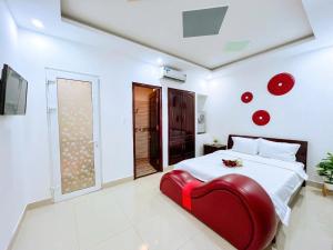 una camera con una sedia rossa e un letto di Hà Đan Hotel - Bãi Sau Vũng Tàu a Vung Tau