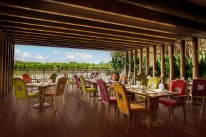 a restaurant with tables and chairs and a large window at An Lam Retreats Saigon River in Ho Chi Minh City