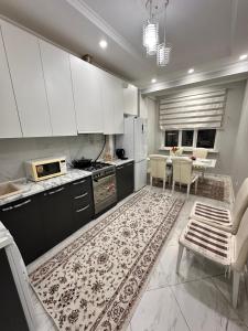 a kitchen with white cabinets and a kitchen rug at Bata in Bishkek